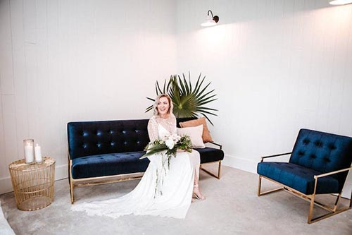 Bride sitting on a black leather couch